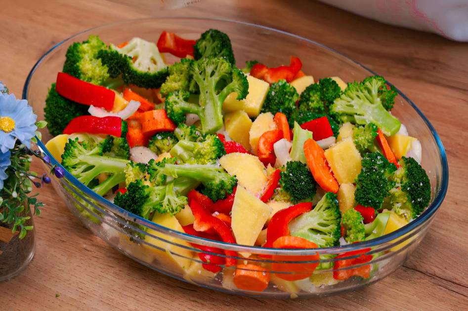 Steaming healthy frozen meal bowl with greens and lean protein on marble counter